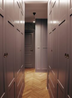 Fyldningslåger på specialbygget bevægelig garderobe med messinggreb og integreret loftsbelysning